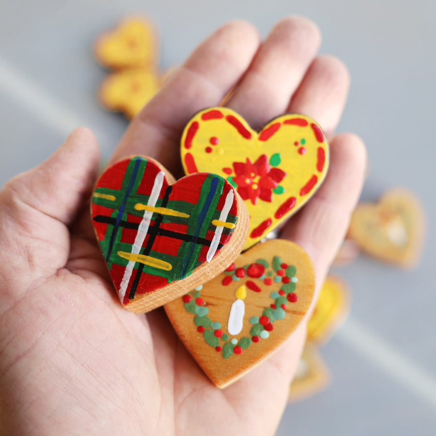Hand-painted wooden hearts with colorful Christmas patterns.