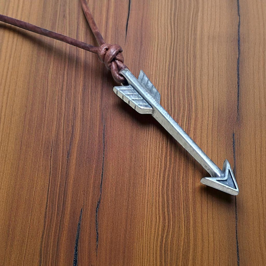 Close view of arrowhead and fletching on leather necklace