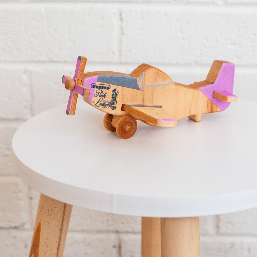 Wooden toy airplane displayed on a small round table