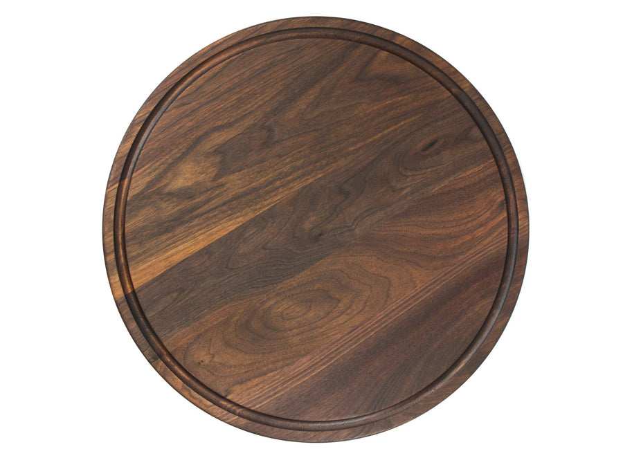 Round walnut cutting board with a circular juice groove