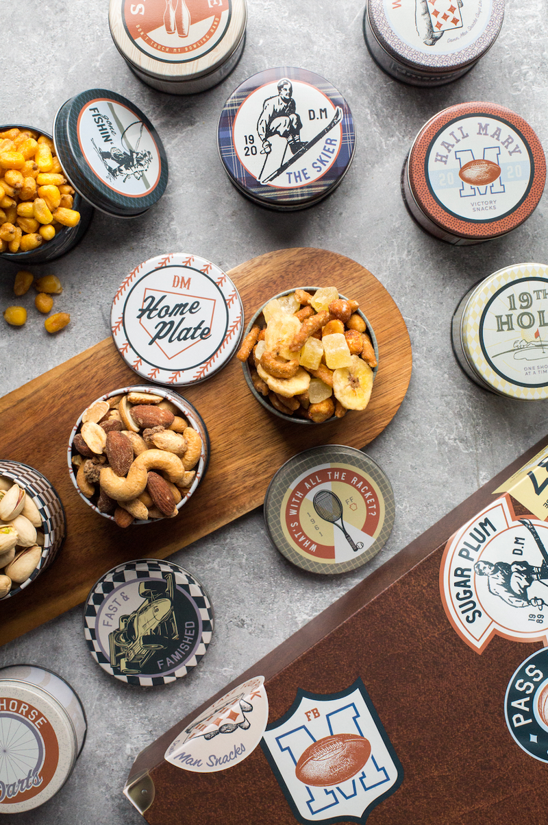 Vintage Bar Cart Snacks assortment in nostalgic tins with pistachios, cashews, almonds, and trail mix displayed creatively on a wooden tray