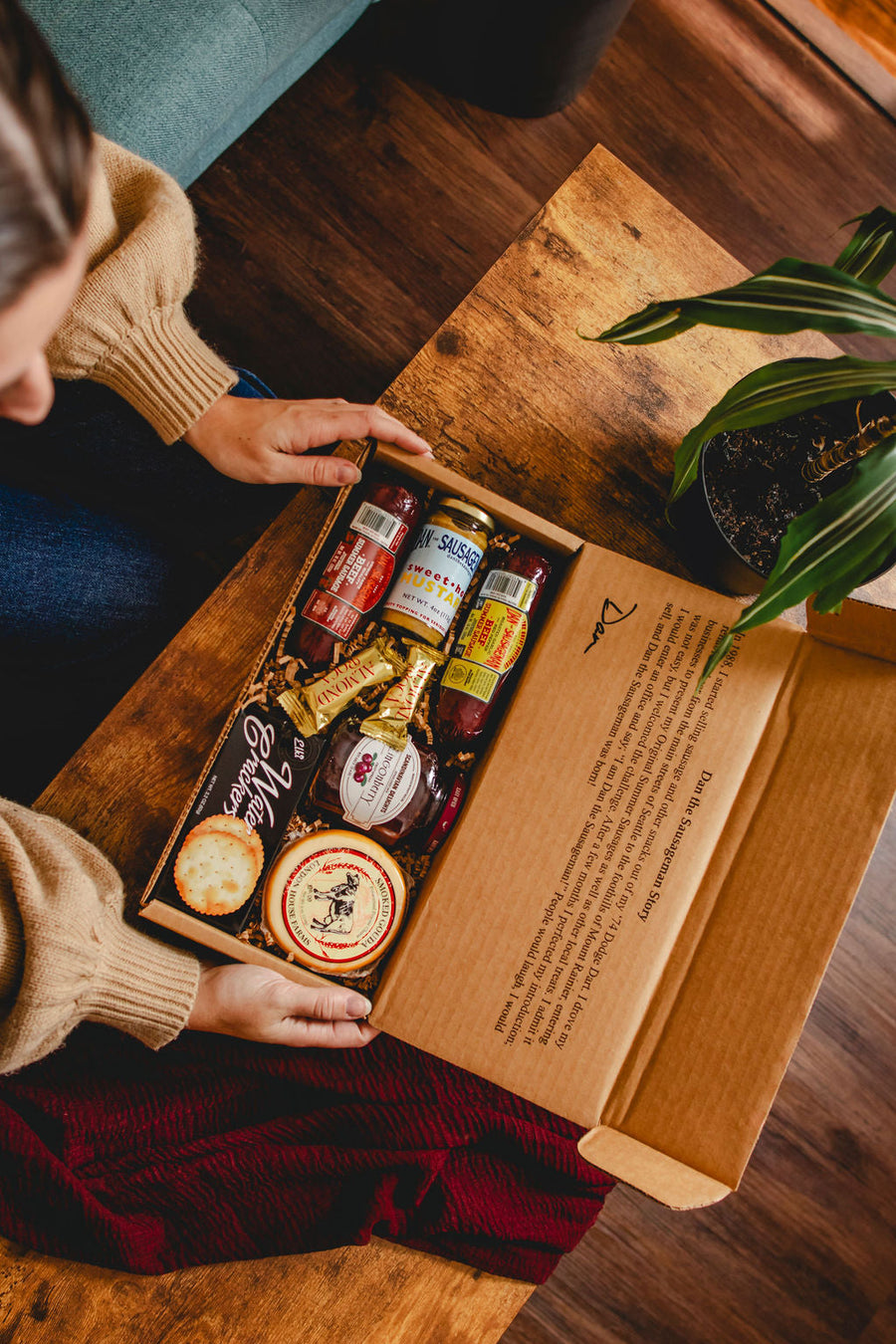 Overhead view of an open Skandia gift box containing sausage, Gouda and lingonberry spread