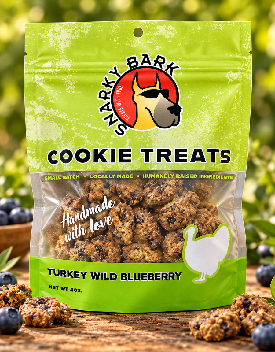 Snarky Bark turkey wild blueberry cookie treats in a green pouch beside cookie pieces