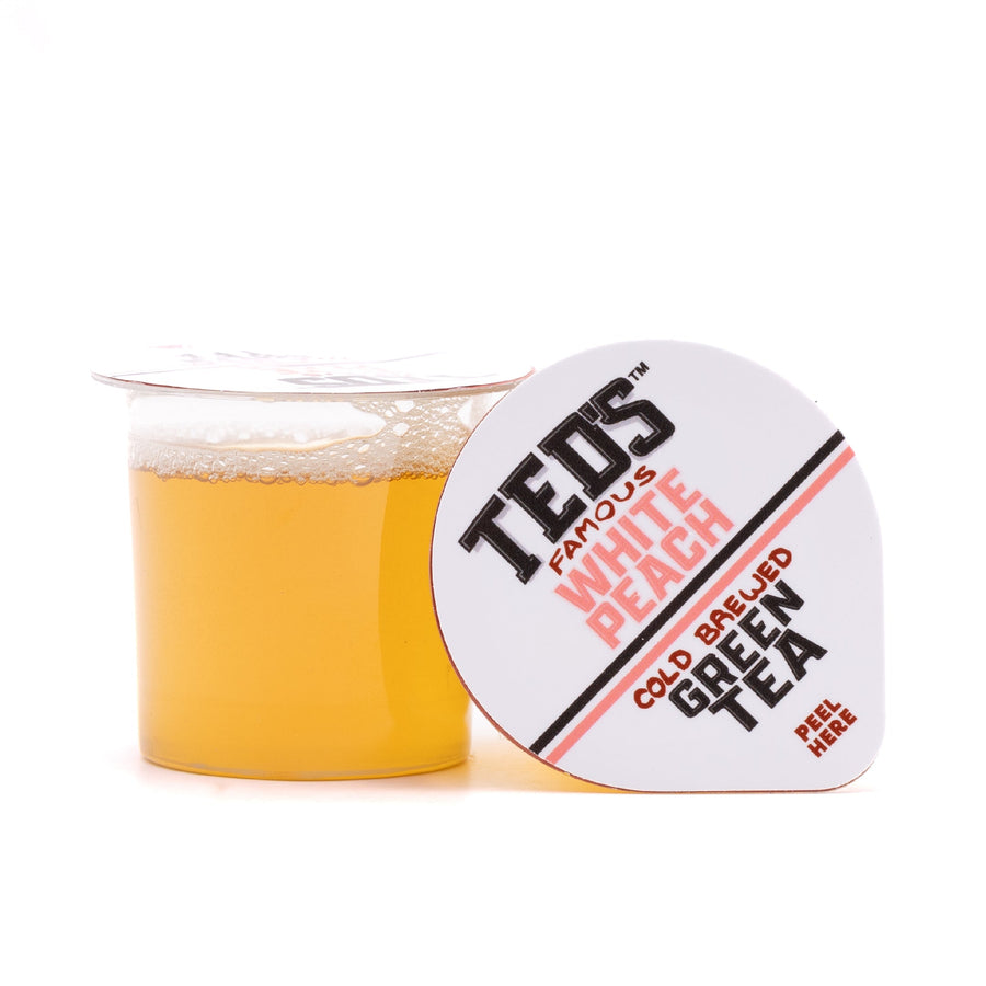 Open white peach tea pod beside lid