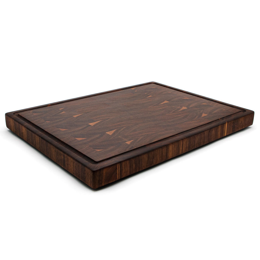 Walnut end-grain cutting board with a thick profile, angled view