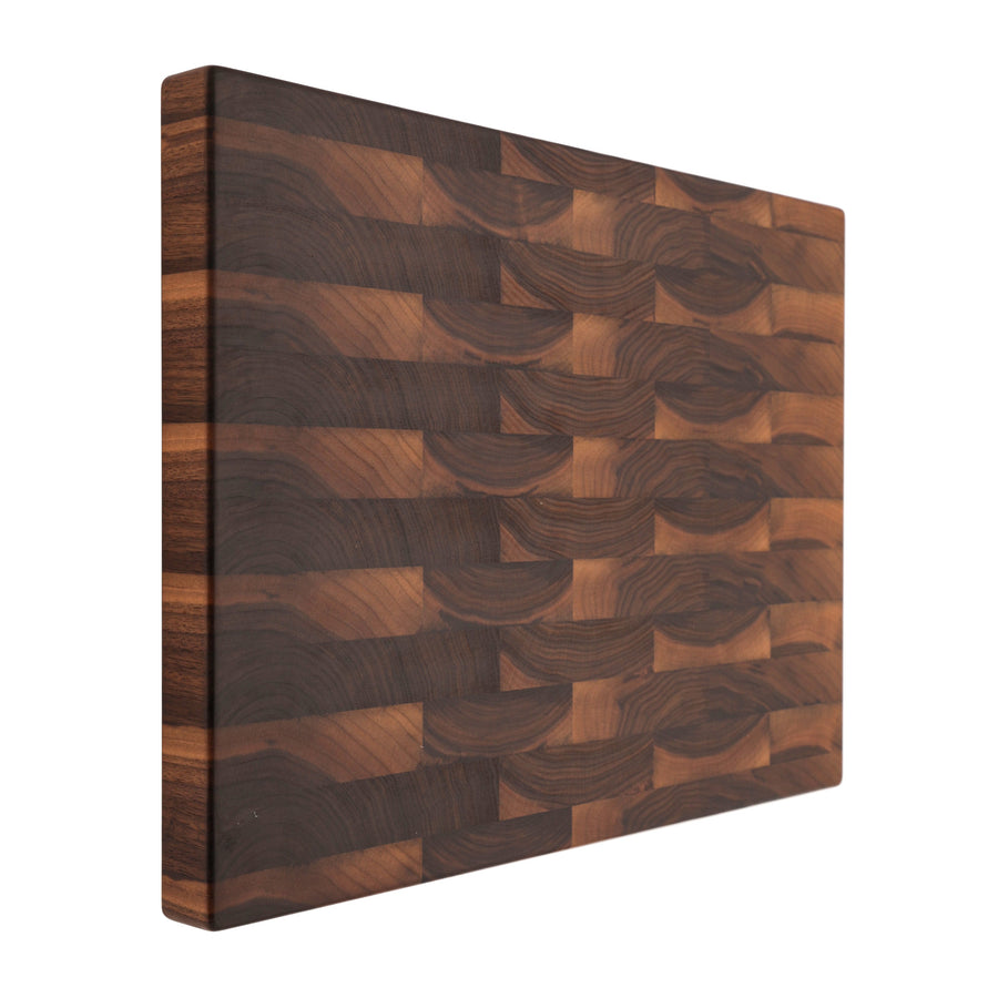 Walnut end-grain board standing upright on a white background