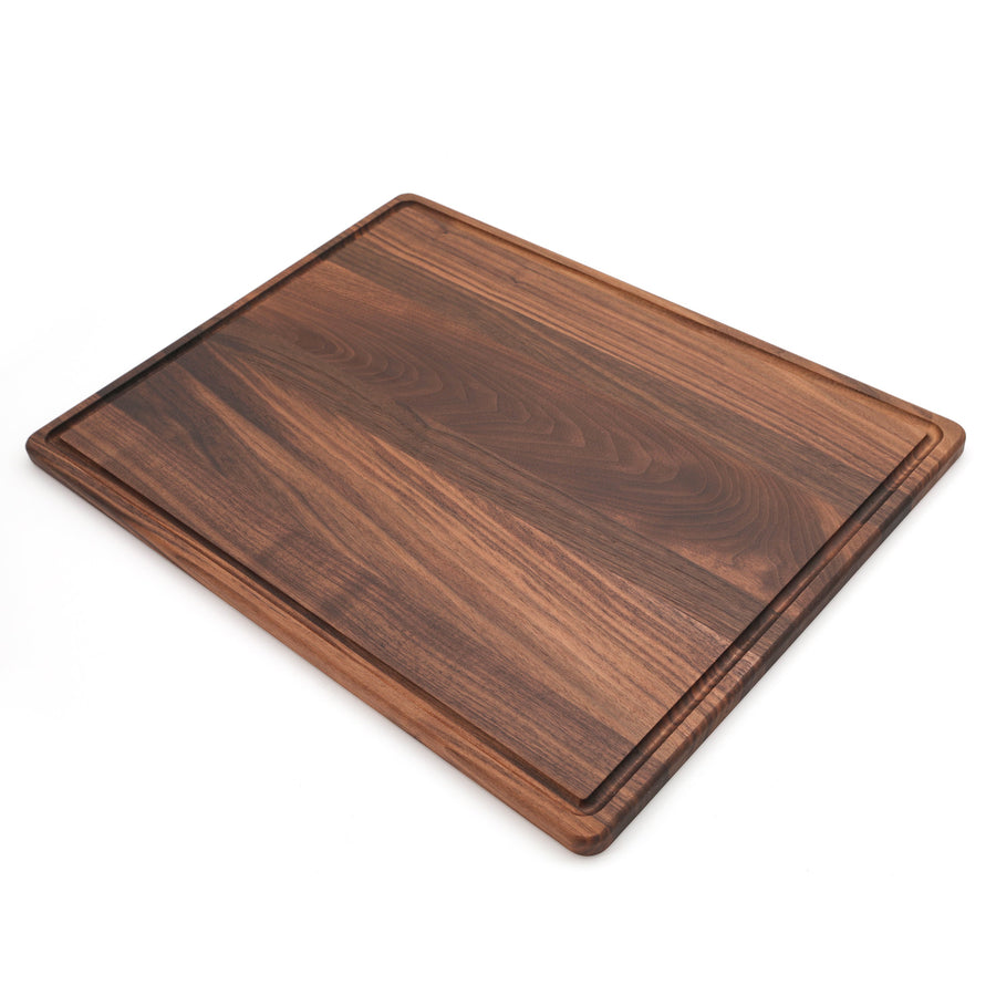 Large walnut cutting board with a perimeter groove, angled view