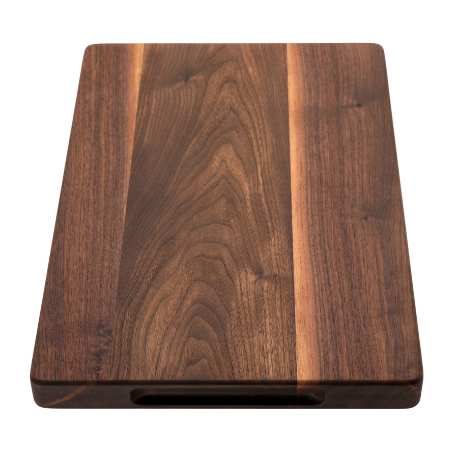 Thick walnut cutting board standing upright to show its profile