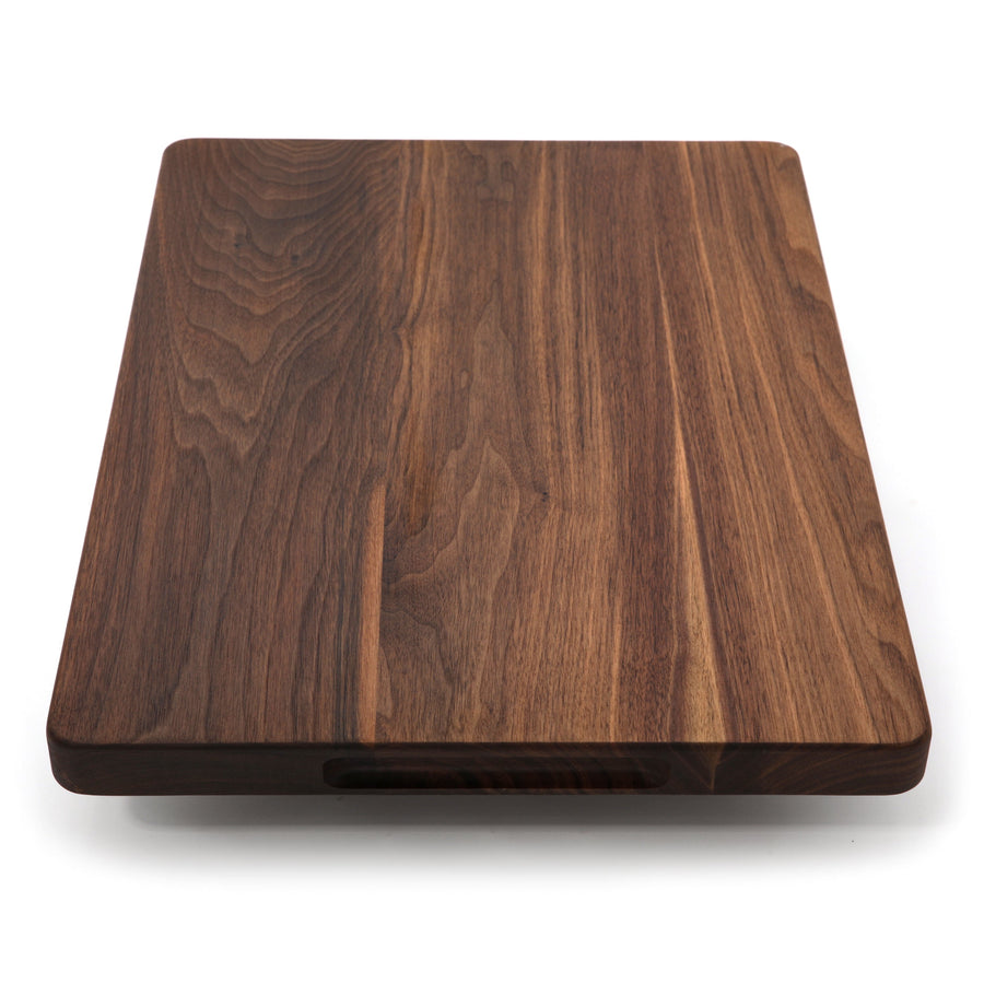 Walnut cutting board standing upright to show its thick profile