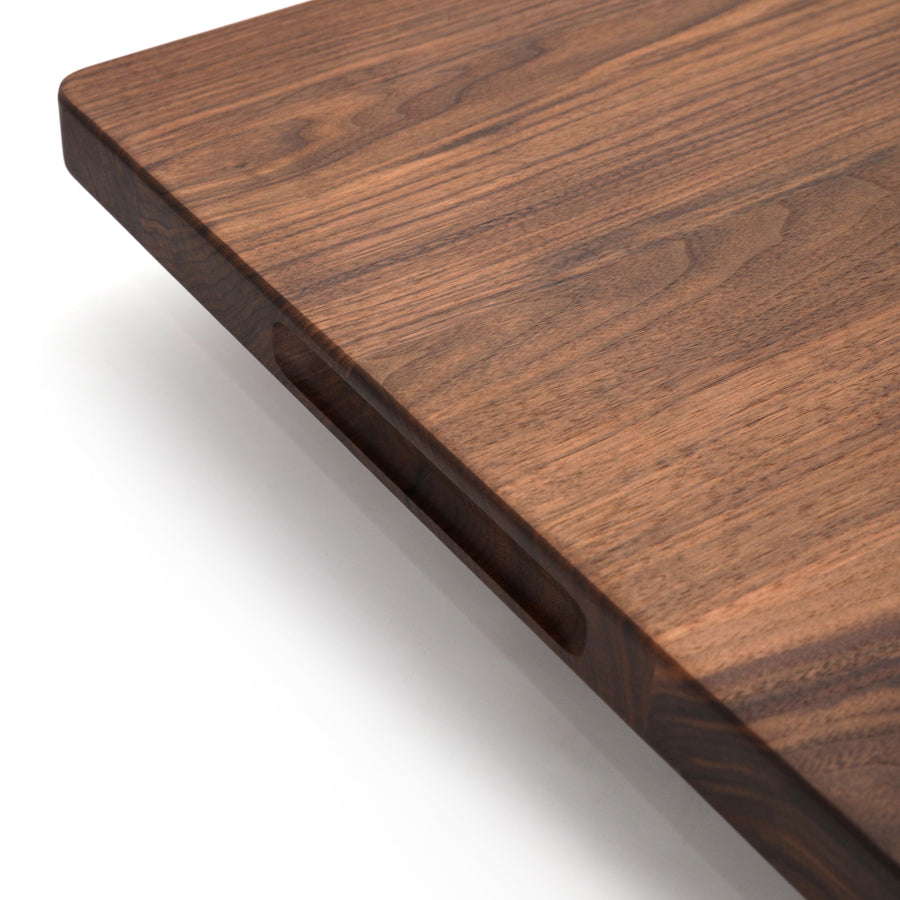 Close view of a walnut board edge and pocket handle