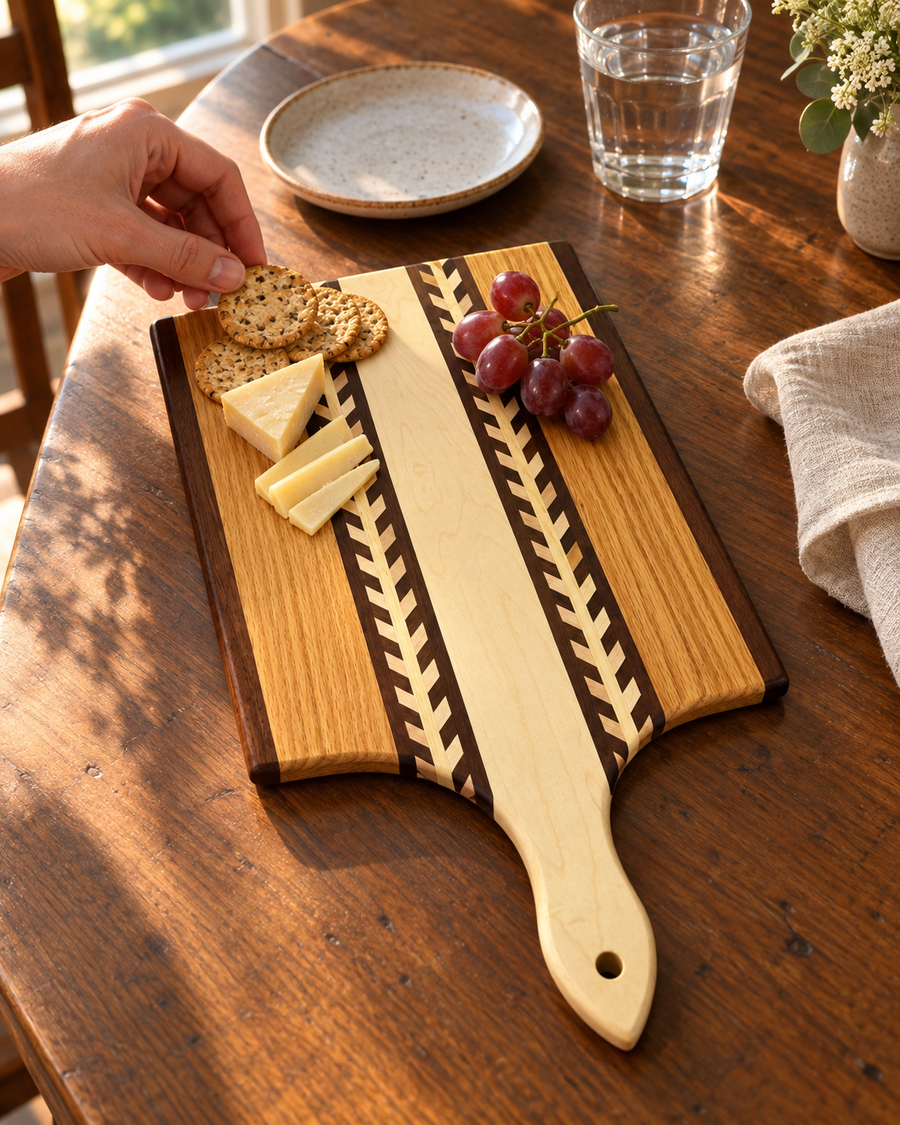 Wheat-pattern paddle serving board with cheese, crackers, and grapes; styled example.