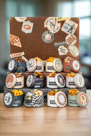 Nostalgic Bar Cart Snacks tins filled with assorted salty snacks, perfect for pairing with beverages in a creative vintage case