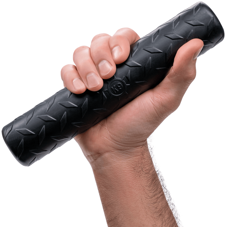 Hand holding a black textured rubber Chew Stick