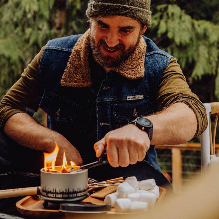 Person roasting marshmallows over the Fall Edition bonfire