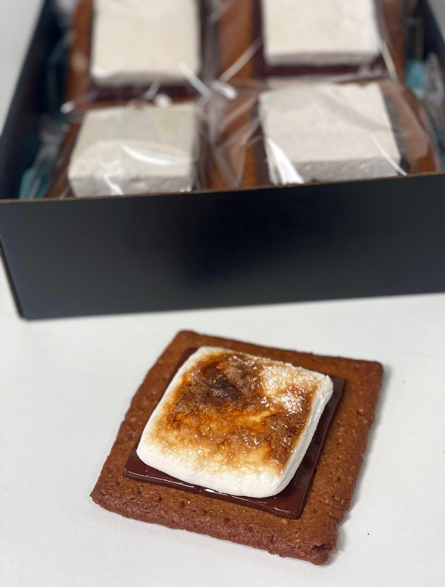 Open box of individually wrapped smores with one toasted smore displayed beside it