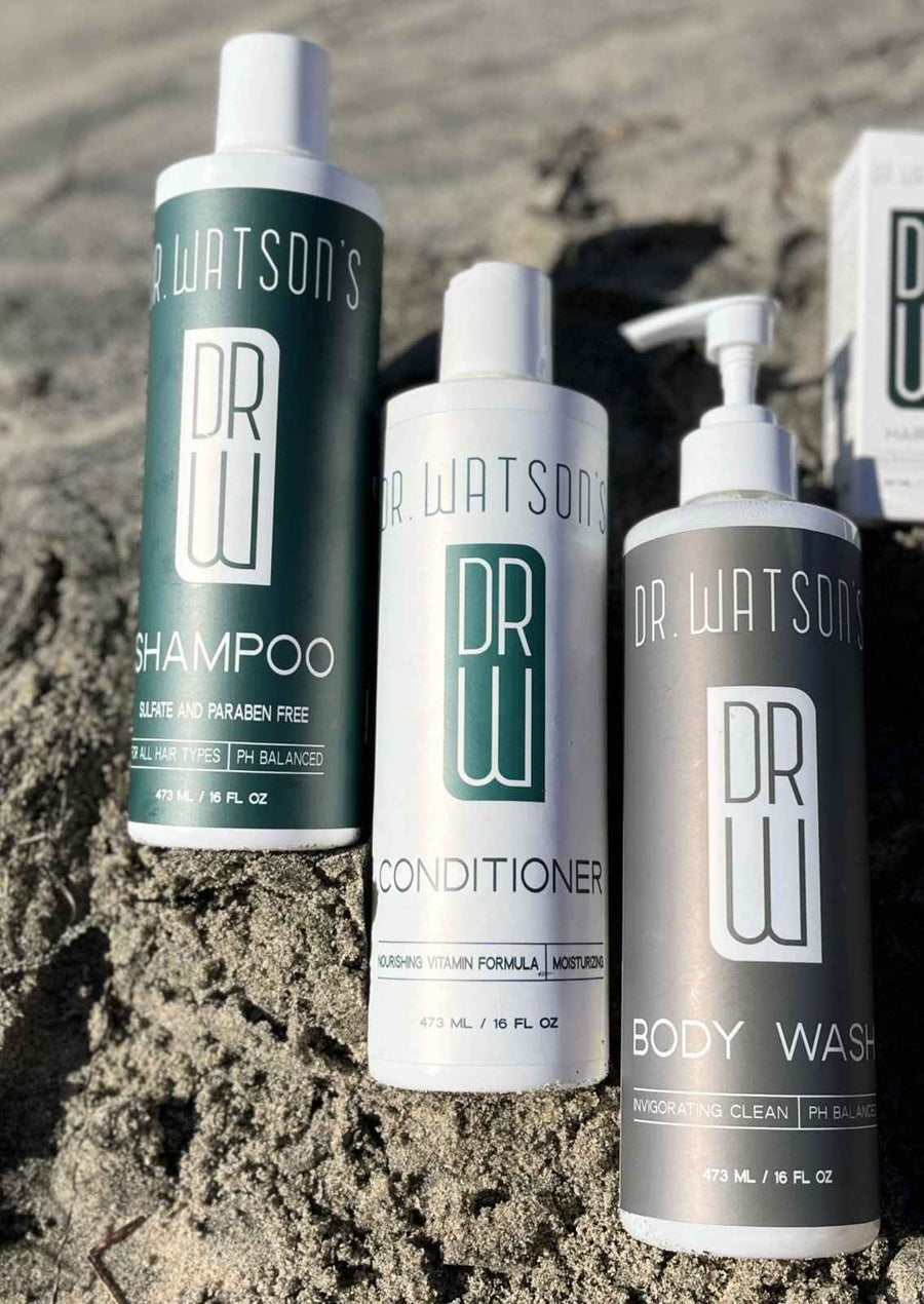 Shampoo, conditioner and body wash bottles on coastal rocks