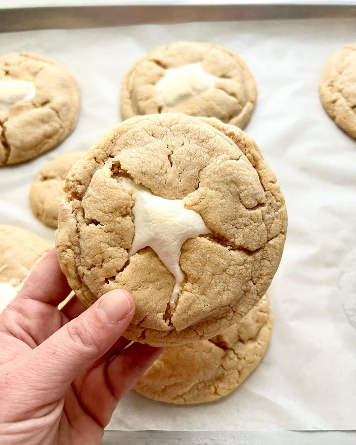 Fluffernutter Cookies — a cookie held above a tray of cookies