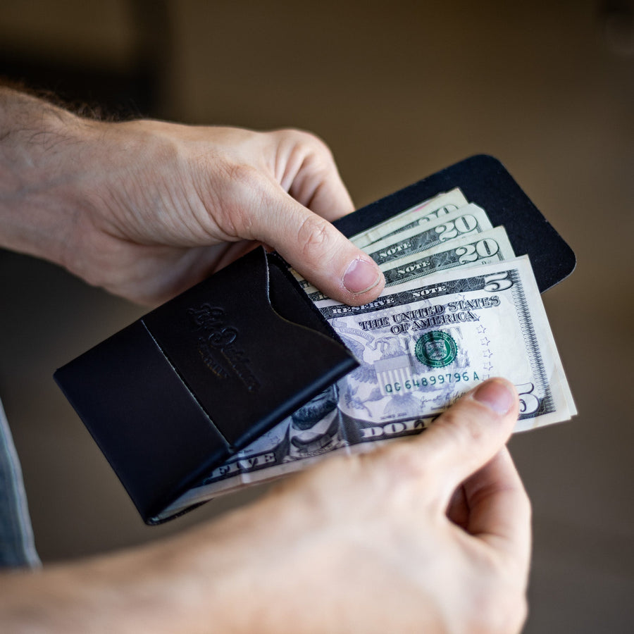 Black Franklin 2 leather wallet, held while bills are inserted through the side
