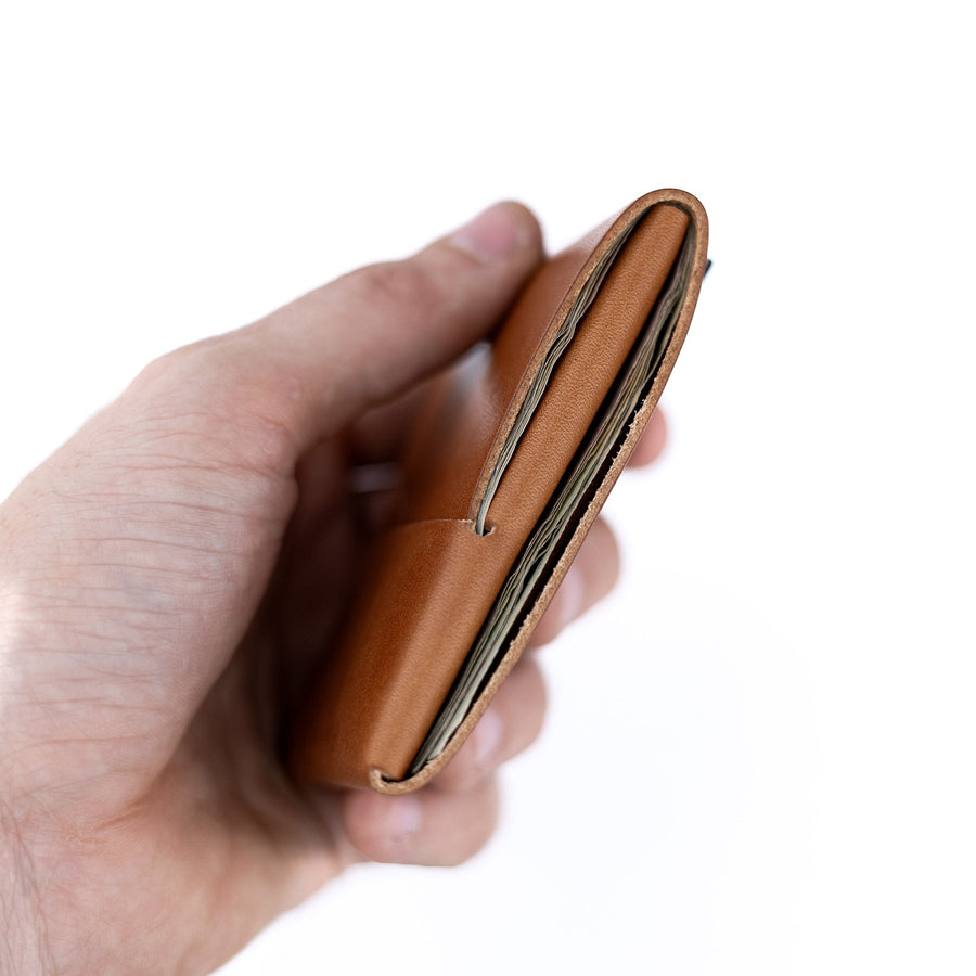 Brown Franklin 2 leather wallet, edge-on view held in one hand