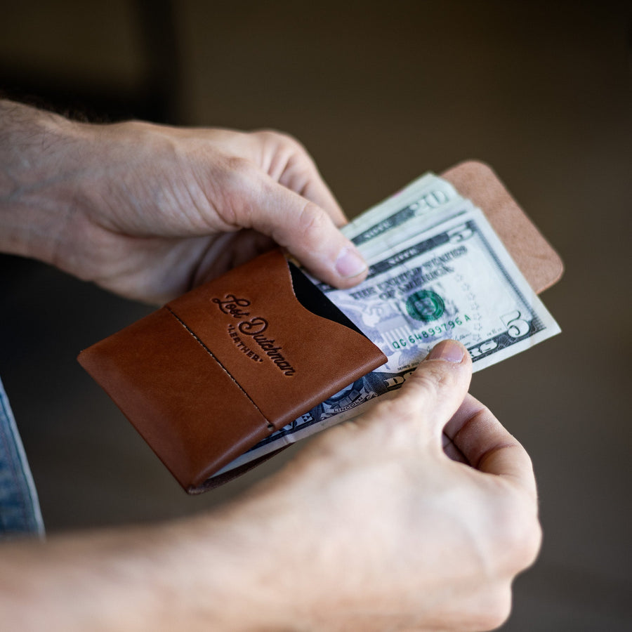 Brown Franklin 2 leather wallet, held while bills are inserted through the side