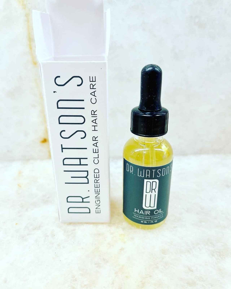 Hair oil bottle and tall white carton on a light surface