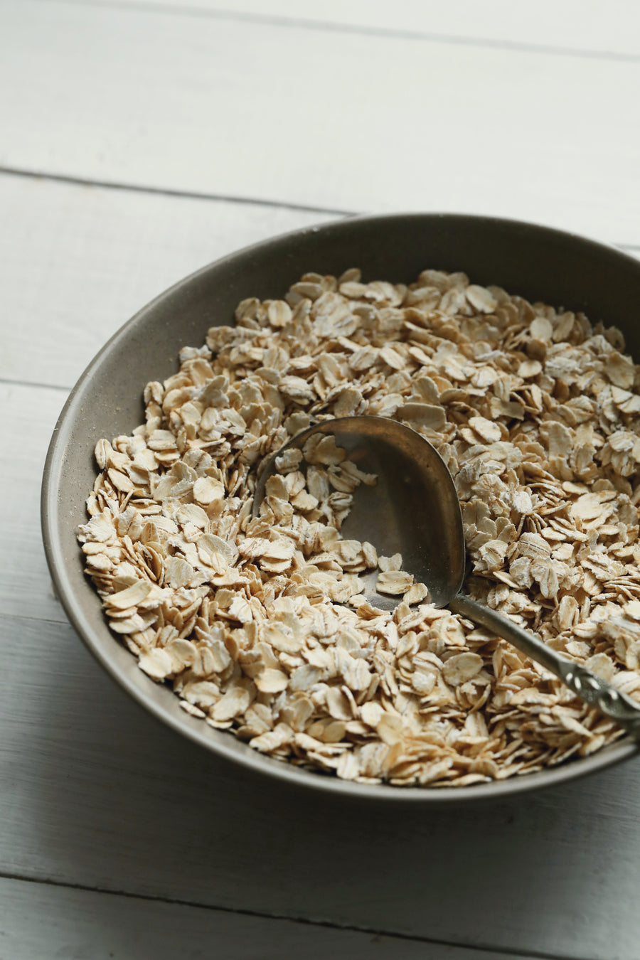 Dry oatmeal in a bowl with a spoon
