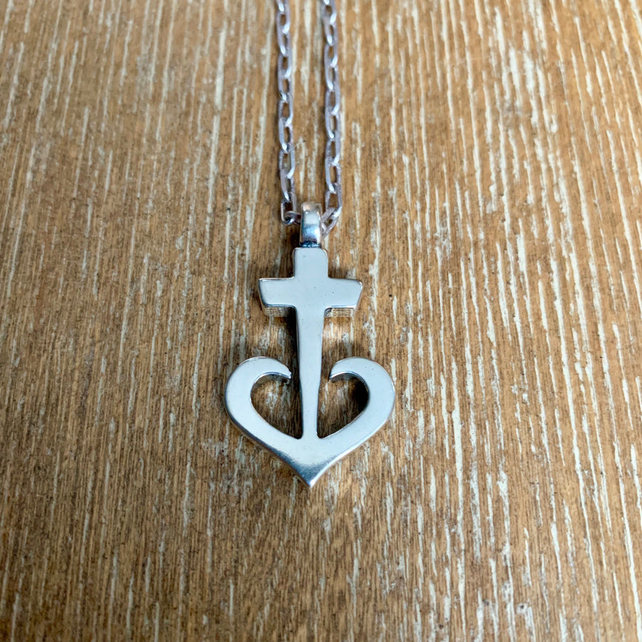 Anchored Heart pendant on chain against wood