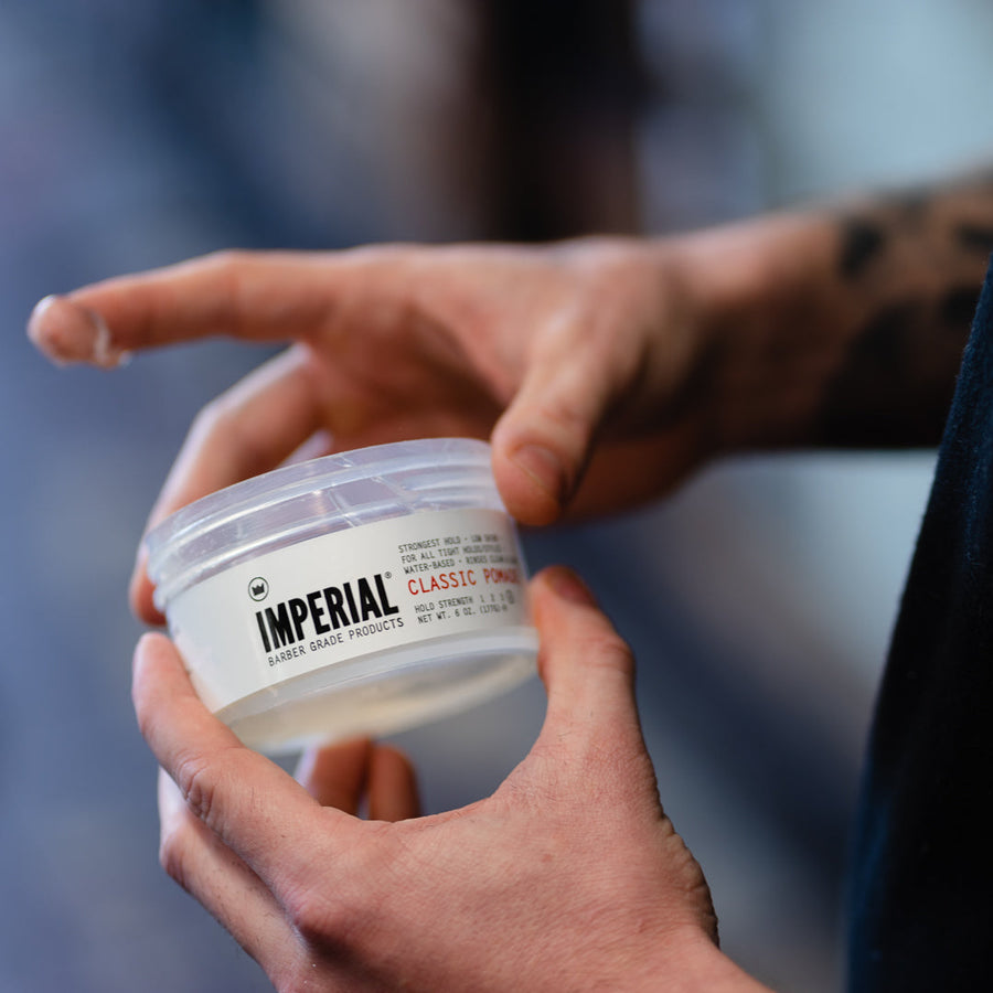 Imperial Classic Pomade — Classic Pomade jar held at a barber station