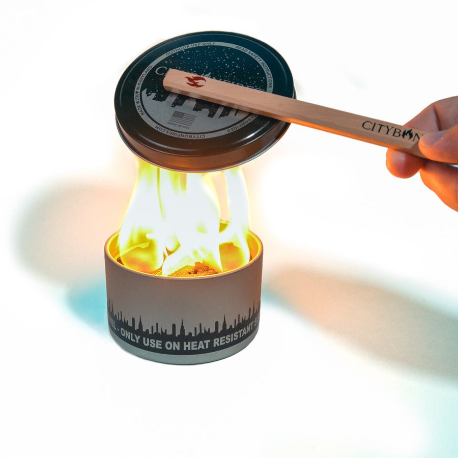 Magnetic wooden Lid Buddy positioning a lid above a bonfire