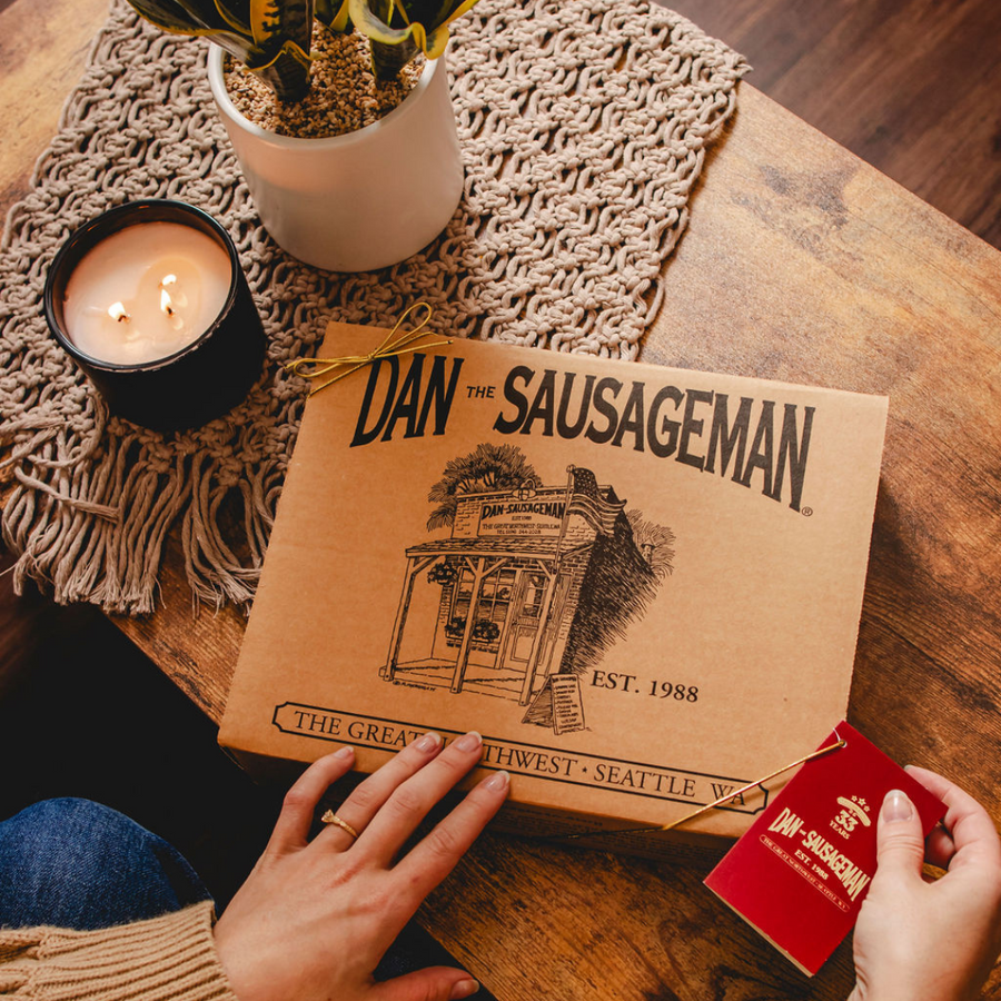 Closed Dan The Sausageman kraft gift box with red tag on a table