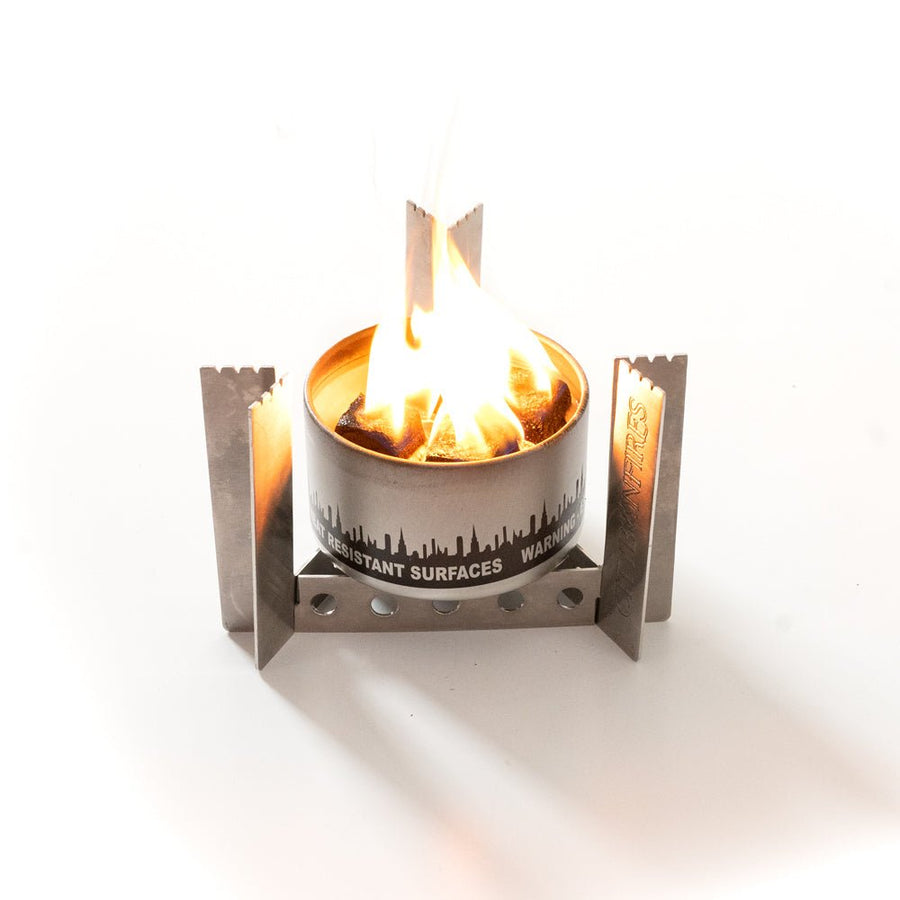 Camp stove inverted as a trivet beneath a bonfire