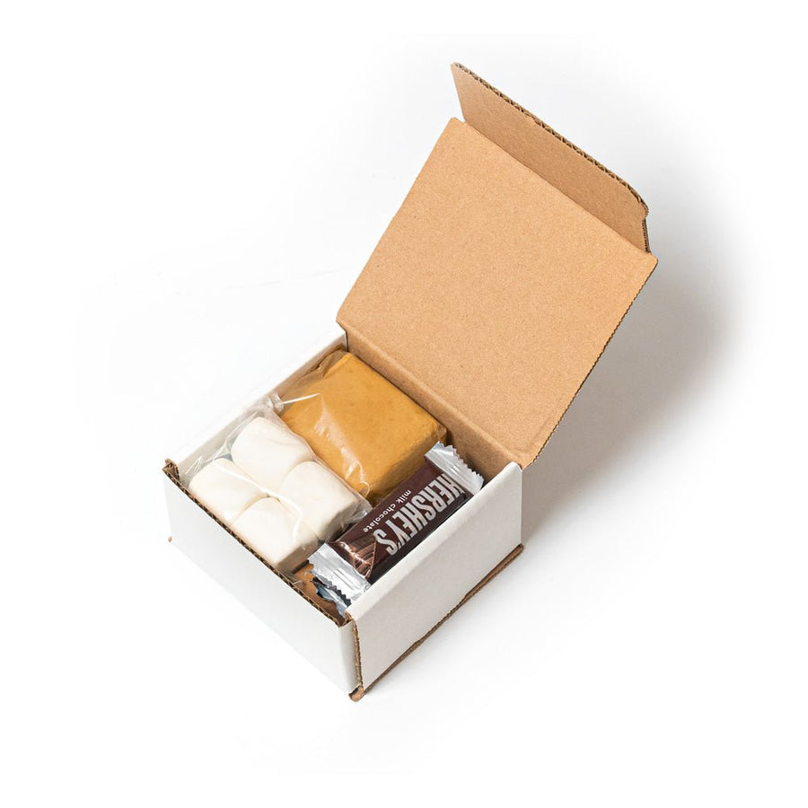 Open s’mores ingredient box with crackers, marshmallows and chocolate