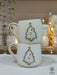 Two handcrafted ceramic mugs with a festive snowman framed in a Christmas tree design, adorned with gold accents, perfect for holiday gifting!
