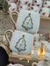 Two elegant handmade ceramic mugs featuring a snowman in a Christmas tree frame. A perfect festive gift adorned with gold accents!