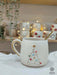 A handmade Star Trek-inspired ceramic Christmas mug featuring a 3D Christmas tree with colorful baubles, a gold star, and a gold handle, perfect for Trekkie fans.