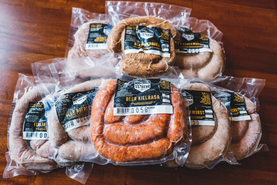 Assorted packaged sausages arranged on a wooden table