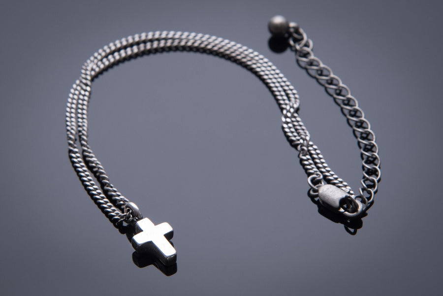 Mini Cross necklace arranged in loops with clasp visible